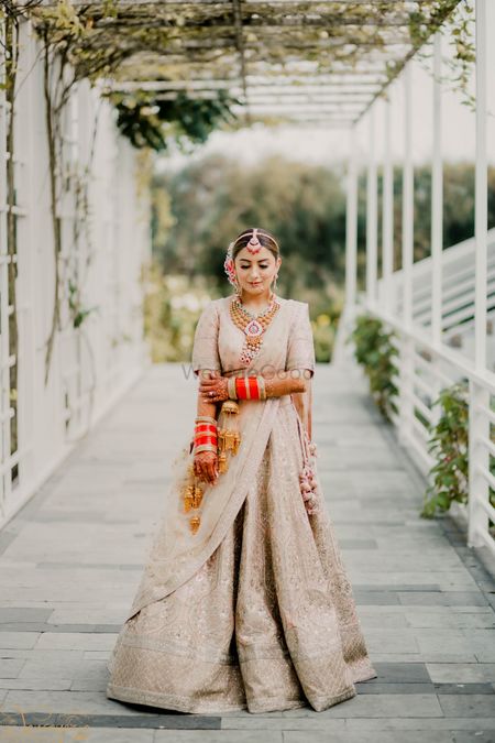 Photo of Bride in a gorgeous pastel pink Sabyasachi lehenga and traditional jewellery