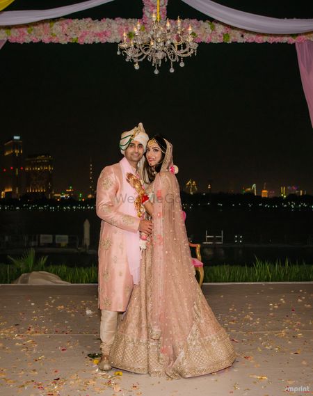 Light pink bride and groom sherwani