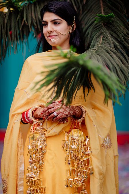 A bride in a simple yellow outfit her haldi