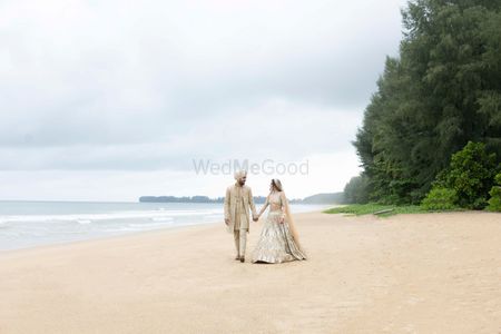 Photo of Candid couple portrait in coordinating wedding outfits at the beach