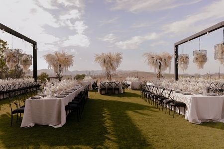 Photo of Elegant black and white themed outdoor table setting with pampas grass
