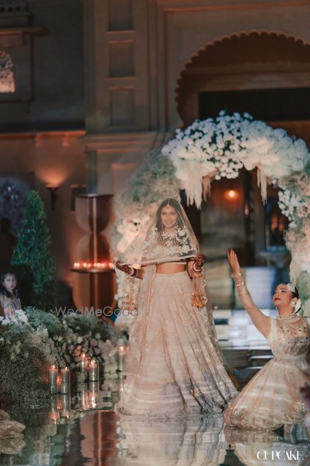 Photo of Royal bridal entry with bride in a white lehenga and sheer veil