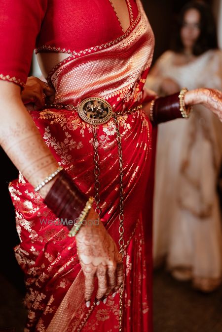 Gorgeous Sabyasachi waist belt with red saree for the wedding day