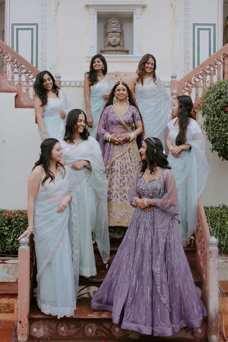 Lovely shot of co-ordinated bridesmaids in pastel sarees and the bride in a lovely lilac lehenga on the wedding day