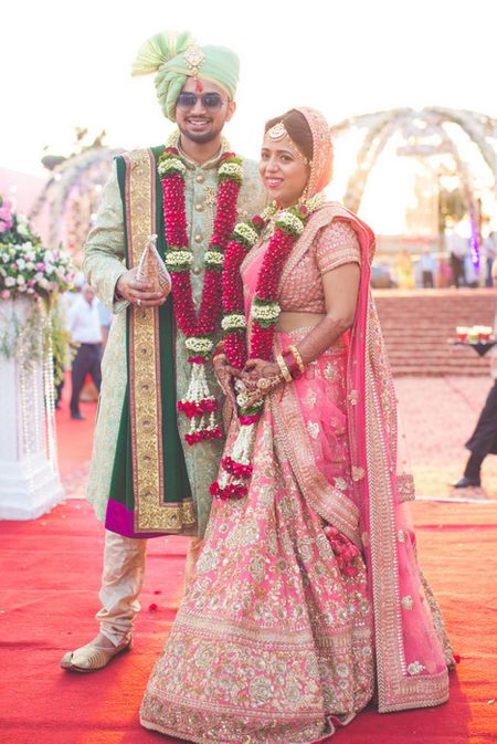 Pink and gold bridal lehenga worn as contrast to groom