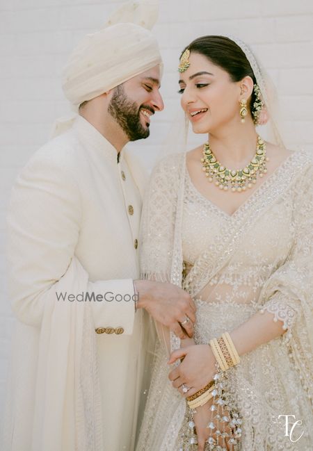 Gorgeous capture of the bride and groom, both in coordinated all-white looks with the bride in a very minimal look