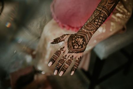 Photo of bridal mehendi back hand design with lotus motifs