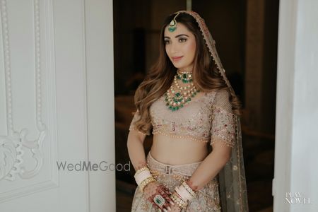 Photo of Timeless bridal portrait with bride in a pastel lehenga, open hairdo and  belt style lehenga on her wedding day