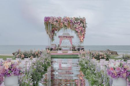 Photo of pastel floral beachside mandap with mirror aisle