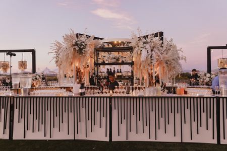 Stunning white and black themed bar decor set up with pampas grass detailing 