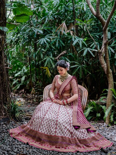Bride wearing ivory and red lehenga on her wedding day.