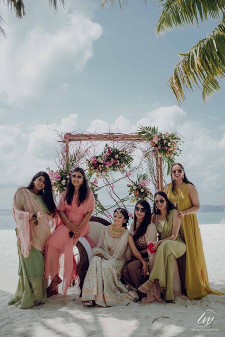 Photo of beach mehendi photobooth with bride and bridesmaids