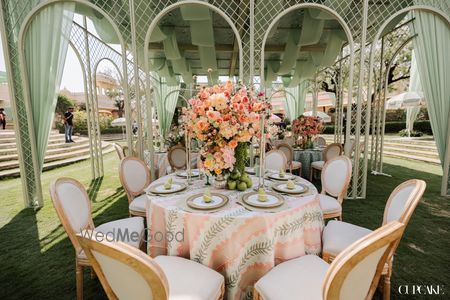 A gorgeous sage and peach themed decor for a round table for an outdoor wedding