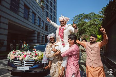 Photo of groom baraat entry idea on groomsmen shoulders