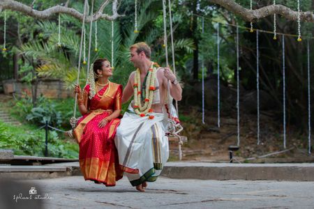 A south indian bride and groom on their wedding day, swinging on a swing