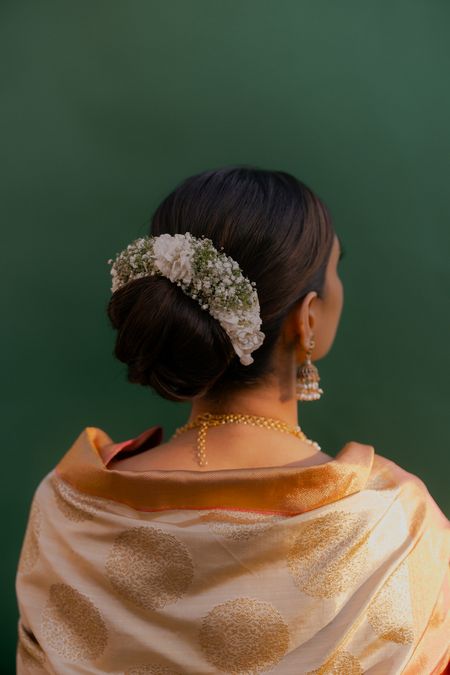 Photo of Minimal bridal bun with baby breath and white floral detailing