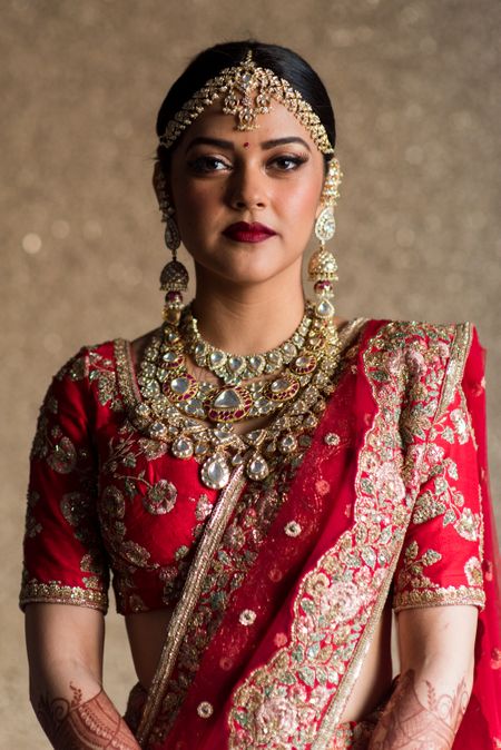 Modern bridal portrait in red and gold lehenga 