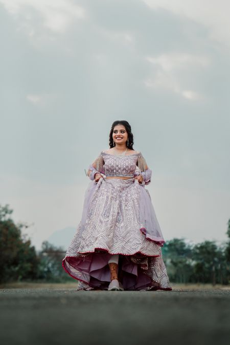 bride wearing lavender lehenga and sneakers for engagement