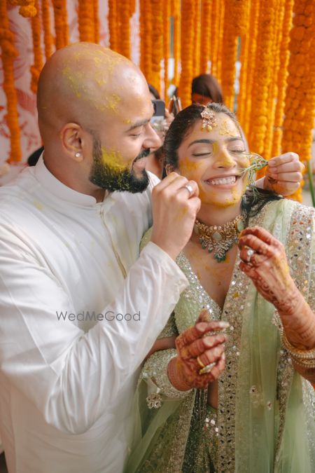 Photo of Lovely couple photo on haldi day with bride in a mint green lehenga with mirrorwork