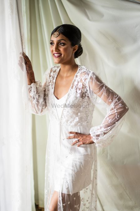 bride getting ready in lace robe before wedding