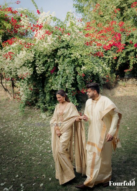 Outdoor shot of the bride and groom in colour coordinated gold outfits 