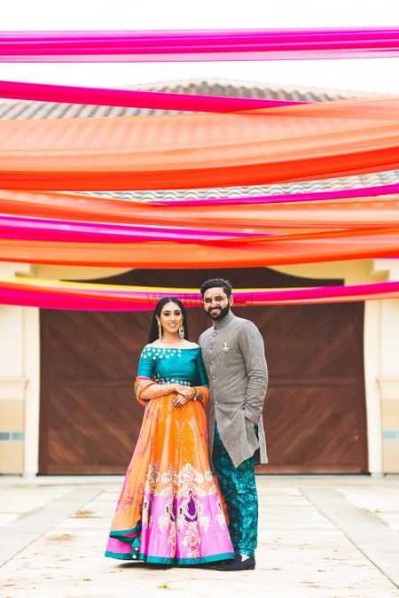 Photo of Mehendi couple colourful portrait with drapes