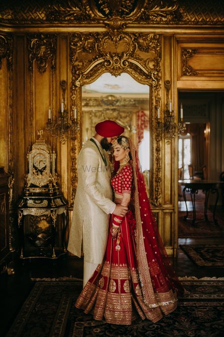 couple pose for regal wedding with bride in red