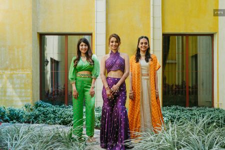 Stunning bridesmaids and bridal portrait with bride in a co-ordinated set with fun sharara pants and a halter neck blouse in aubergine