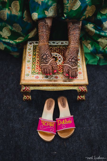 A bride flaunting the bridal mehendi design on her feet
