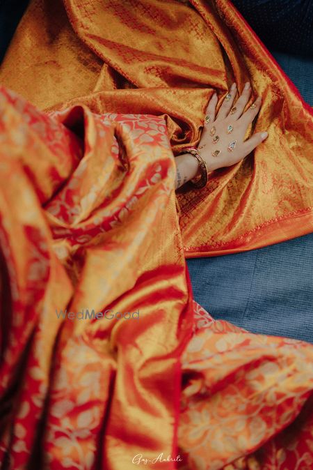 Gorgeous embellished mehendi for the bride with an orange kanjeevaram saree