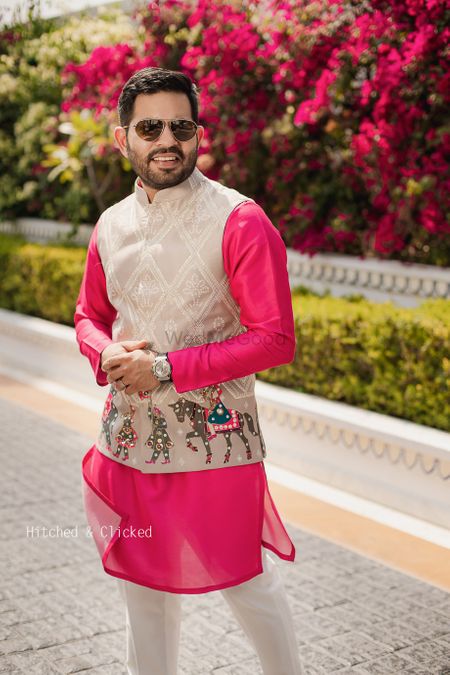 Photo of groom wearing bright pink kurta with baraat embroidery nehru jacket