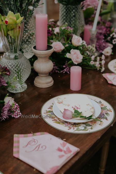 Photo of Gorgeous pink and white table setting with floral and candle elements