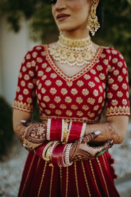 Photo of bride wearing a classic red chooda shot