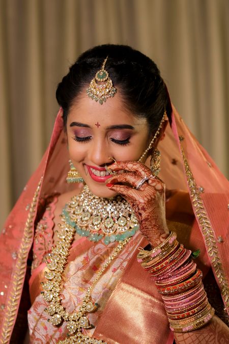 Close-up shot of a bride dressed in a pink kanjeevaram. 
