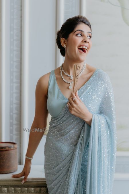 Powder blue sparkly saree for the sister of the bride with layered diamond jewellery