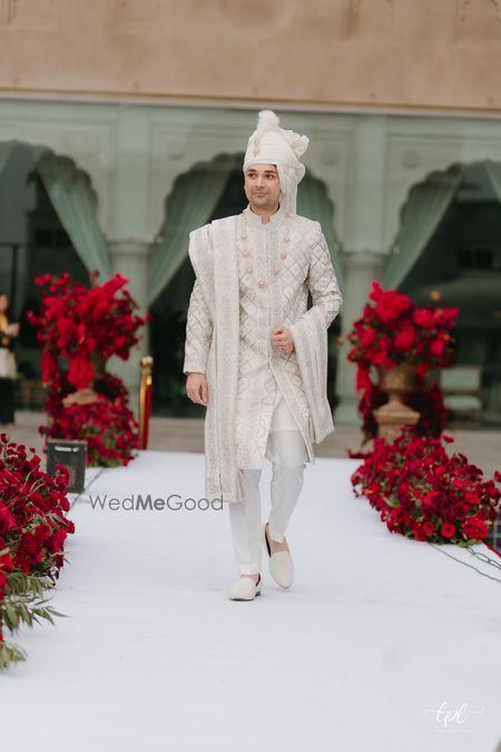 Photo of Royal groom look in an all white sherwani and pearl jewellery