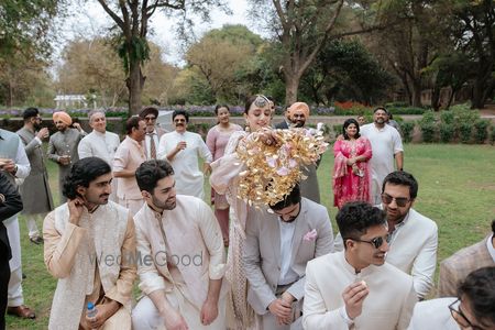 Photo of Fun photo of bride dropping kaleeras on her brothers and bridesmaids