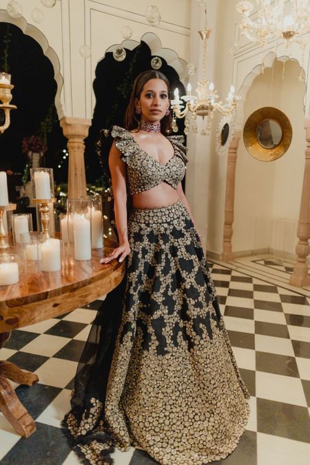 Fun and gorgeous bridal shot in a black lehenga with gold detailing for a sangeet night