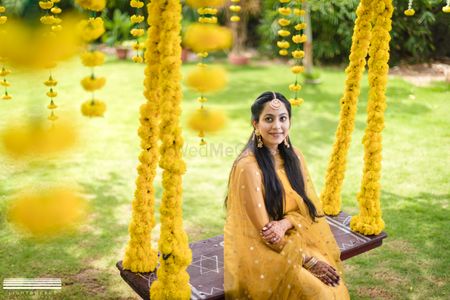 Haldi swing decor with bride in yellow 