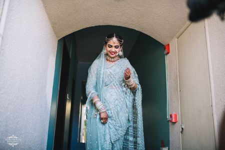 A bride in a tiffany blue saree and multistrand mathapatti
