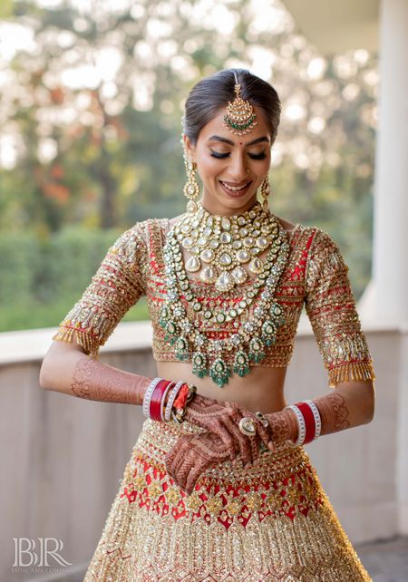 Heavy red and gold bridal lehenga with layered jewellery 