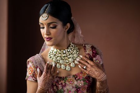 contrasting polki bib necklace on bride with sabyasachi lehenga