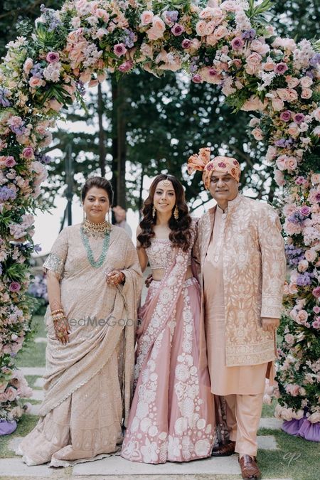 Photo of Lovely photo of the sister of the bride in a dusty pink lehenga with the parents of the bride