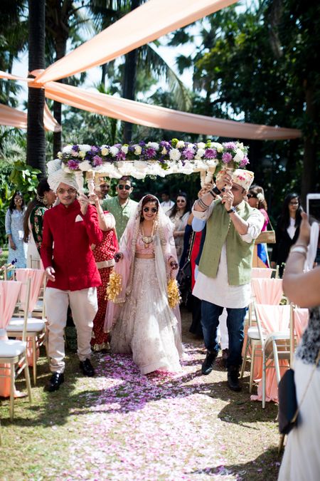 The bride entering with her brothers under a gorgeous phoolon ki chaadar 