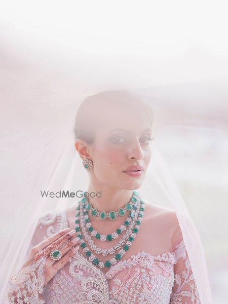 Photo of Stunning diamond and emerald solitaire necklaces layered with matching earrings and rings