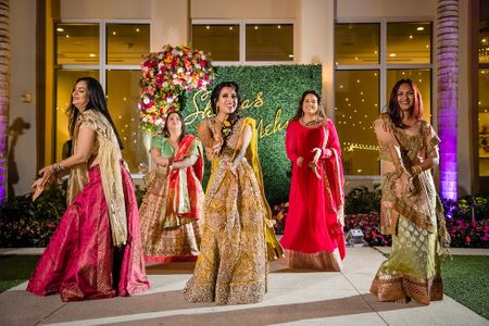 Bride and bridesmaids dancing on mehendi together