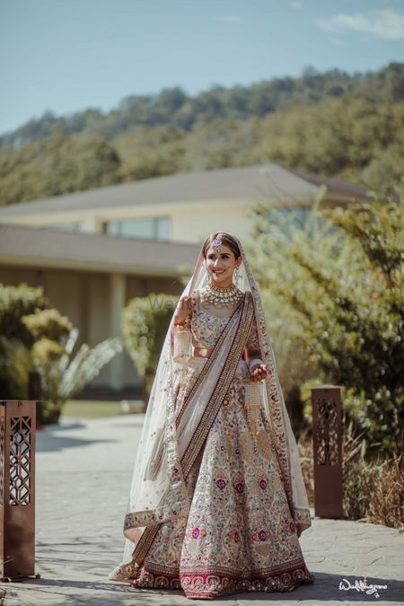 bride in a white lehenga with maroon border and floral motifs