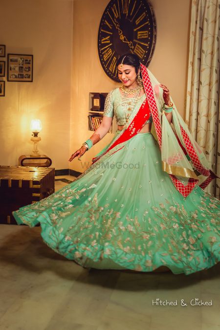 Bride twirling in red and green light lehenga 
