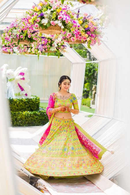 Photo of Bride in lime green and pink lehenga on mehendi