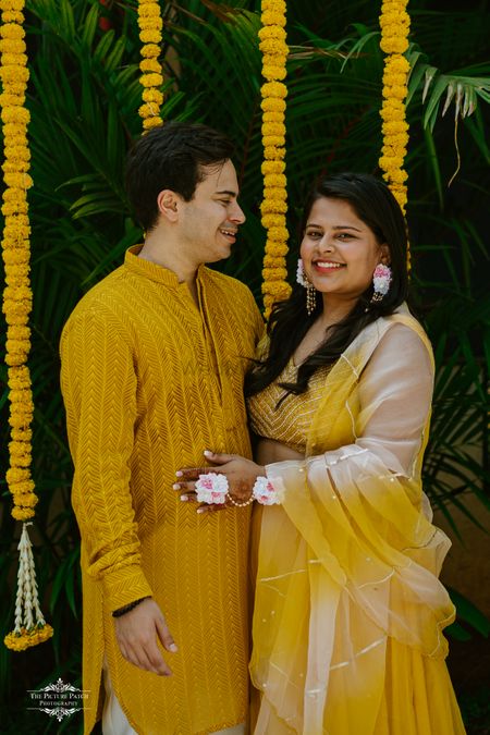 couple wearing matching yellow outfits on haldi 